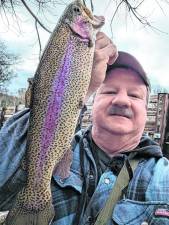 FI1 Earl Hornyak holds a trout that he caught on opening day, Saturday, April 5. He and his friend Bill Repasy took a difficult path through dense shrubbery to get to an exceptional location with huge trout. (Photo by Bill Truran)