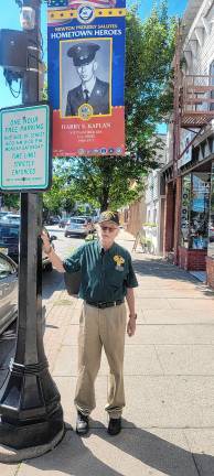 Kaplan to be parade grand marshal Harry Kaplan, who will be grand marshal of the annual Memorial Day Parade in Newton, stands under a banner honoring his military service.