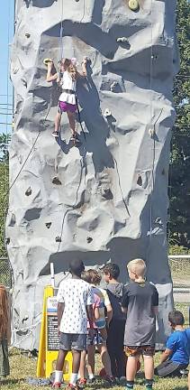 Hardyston holds fall Festival Children watch a girl as she climbs the wall and patiently wait their turn to climb