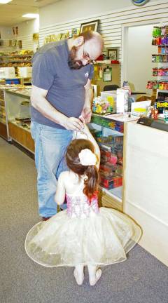 Store employee Sean Harby of Franklin helps a young ballerina with her purchase.