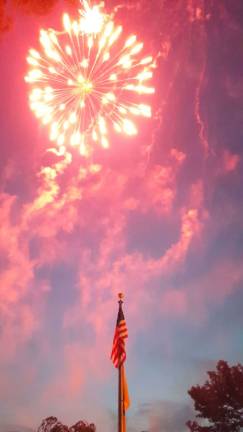 This photo provided by a reader shows fireworks over the American flag during the July 4 celebration.