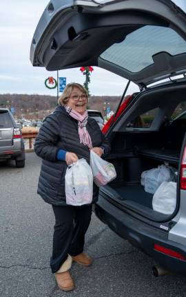 ST2 Volunteer Ruby Young unloads a car full of donations from Ames Rubber.