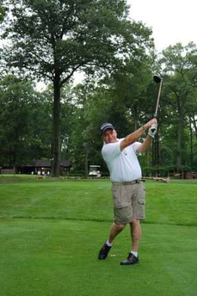 Teeing off on the first tee is Dave Alonso, father of Aaron Alonso who was severely wounded in Afghanistan where he lost both legs.