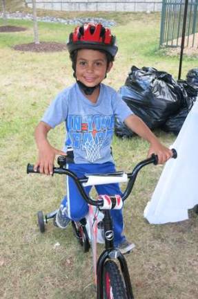 TransOptions, Cycle Craft distribute bikes at Project self Sufficiency Giani Amato of Franklin on a new bike provided by TransOptions and Cycle Craft.