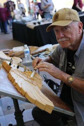 Jim Whitman of Lafayette demonstrates wood carving on an eagle wing.