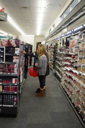 A mother and daughter peruse the cosmetics aisle.