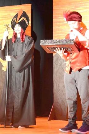 Jafar, played by Bradyn Husarenko, and Iago played by Weslee Dransfield, plot with their evil book of spells to overthrow the Sultan of Agrabah.