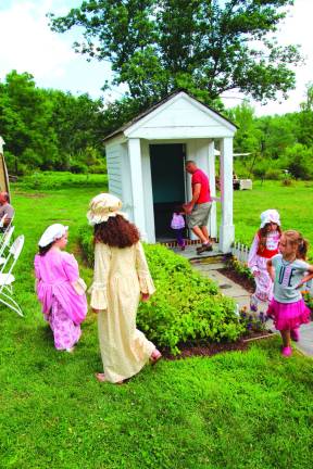 Children give tours of the original outhouse at the DAR Museum.