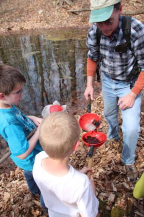 Area children get look at vernal ponds Kevin Mitchell showing the difference between frog and salamander eggs.