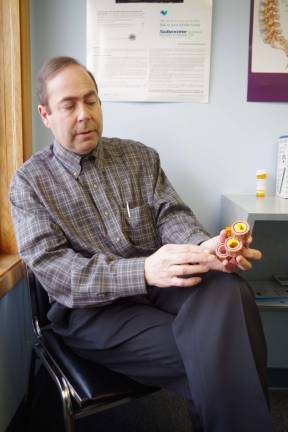 In his downtown Vernon offices, Dr. Blair Beltzer describes the various stages of cardiovascular disease and atherosclerosis with the help of a device that shows the early and advanced stages of the disease in an artery.