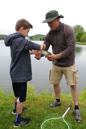 Being aided by his father Damon, Andover Township resident Nicholas Arapkiles, 11, is shown with a 12-inch small-mouth bass.