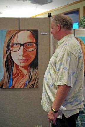 Hardyston resident John Clark pauses to look at a portrait created by Highland Lakes artist and Vernon Township High School art teacher Doug Miller.