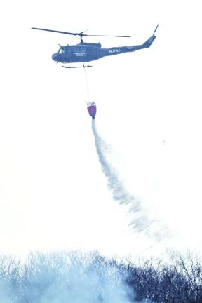 A state fire service helicopter drops water over the Vernon fire on Tuesday morning.