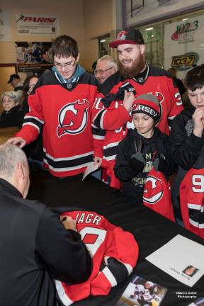New Jersey Devils alumnus Bruce Driver signs autographs for fans at the Monarchs event.