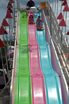 Two girls make their way down the very high and very long Fun Slide.