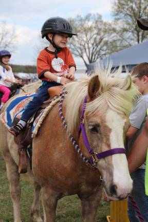 Raphael Korczynski of McAfee gets a pony ride at the rodeo.
