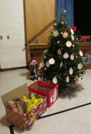 A smalal tree and boxes for a holiday food drive is shown in the Lafayette school gymnasium.