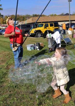 Temperance Settembrino of Franklin runs through the mass of bubbles at Frankin-Fest Open House in Franklin.