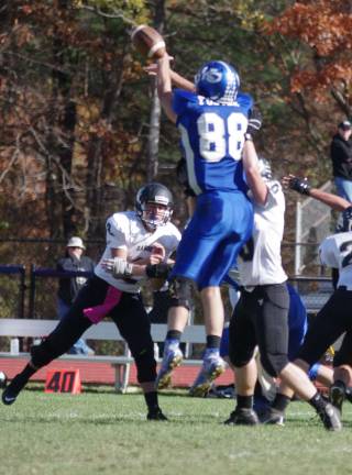 Kittatinny defensive lineman Tyler Foster leaps high into the air to block the ball thrown by the Wallkill Valley quarterback.