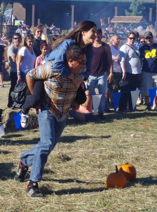A couple is shown competing in the &quot;Wife Carrying&quot; races.