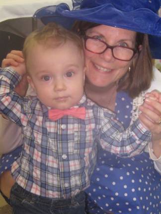 Rosary Society President Loretta La Gala poses with Baby Joseph who attended last year's tea when he was only an infant. Joseph shows off his suave pink tie.