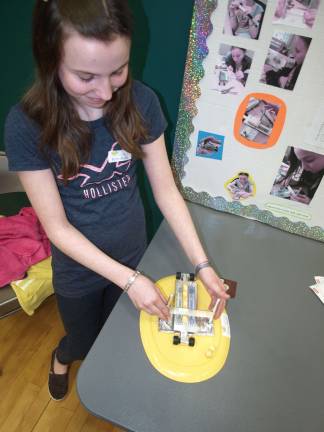 Students get thinking at science fair Jade Lally, demonstrating her "Butta Blade" — a device for precisely measuring and cutting pats of butter.