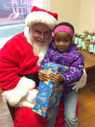 Tauris Williams, 3, visits with Santa at the Family Promise annual Holiday party.