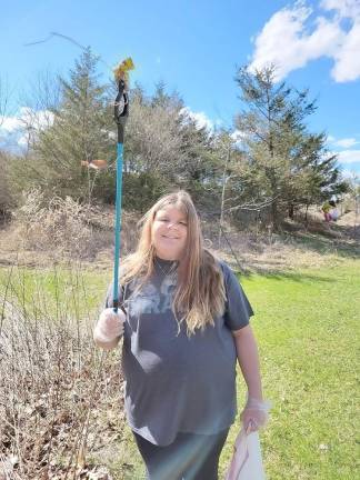 Girl Scout Brooke Jensen, smiling with a grabber tool in hand.