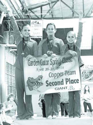 Garden Gators post successful scores in Hackettstown Representing the Copper Gators as they receive their teams' banner are Audrey Biss, Morgynn Witt and Reese Abrams.
