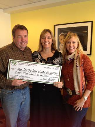 Photo provided Beth and Tim Tiger, founders of Durga Tree present Sarah Symons of Made By Survivors with a $40,000 check from the fall Gala at the Hudson Farm Club in Andover.