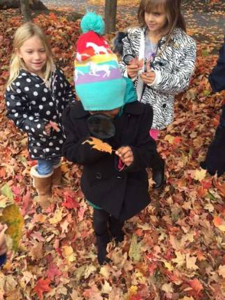 Maddisyn Ross and Zariah Moore examines leaves with their magnifying glasses.