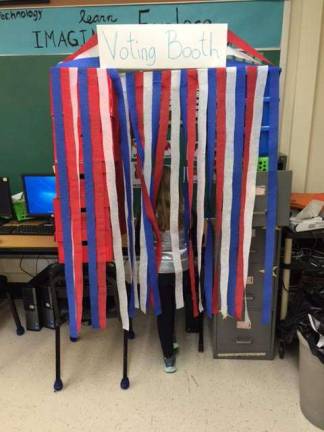 A student casting her vote in the voting booth.