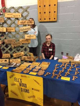 Fourth-grade student Ella Darvalics selling her homemade wood signs.