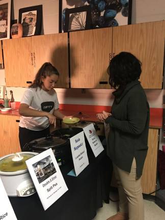 Student member Hannah Panzarella serving soup to teacher Jen Dow