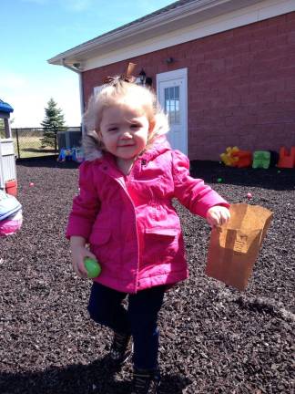 Emma hunts for eggson outside on the playground.