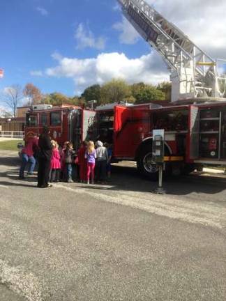 Amanda Bonney and her first-grade class learn what a ladder truck has and does.