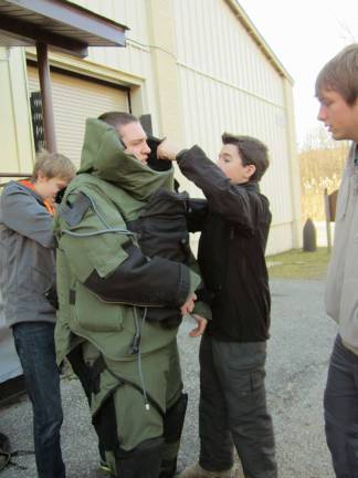 Venturing Crew visits Picatinny Arsenal Crew members help Treasurer Thomas Seltzer put on a bomb suit.