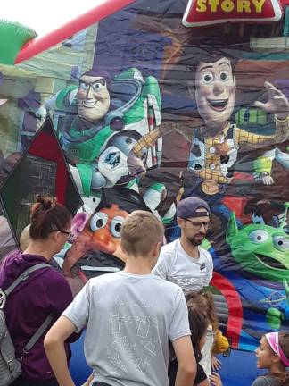 Children enter a Toy Story bounce house.