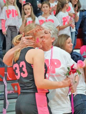 A cancer survivor receives a rose from a High Point Varsity Girls' team member.