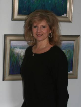 Donna Gratkowski with her paintings in the Featured Artist Gallery at Unity of Sussex County