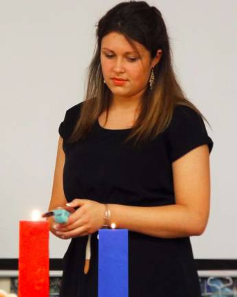 Senior Taylor Hendrickson and NAHS President lights the red primary candle, which signifies passion, love, courage, vitality and power.