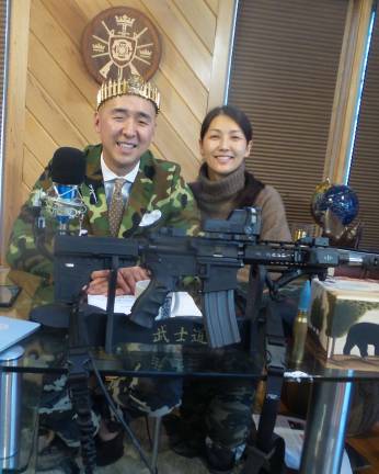 Local church to hold four-day celebration of assault rifles Hyung Jin Moon (Sean Moon), pictured with a crown of bullets, with his wife, Yeon Ah Lee Moon, and an AR-15 (Photo by Frances Ruth Harris)