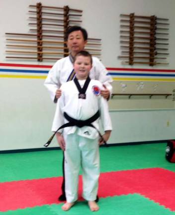 Grand Master Kim of Kim's Martial Arts is shown with student Warren Yunkunis.