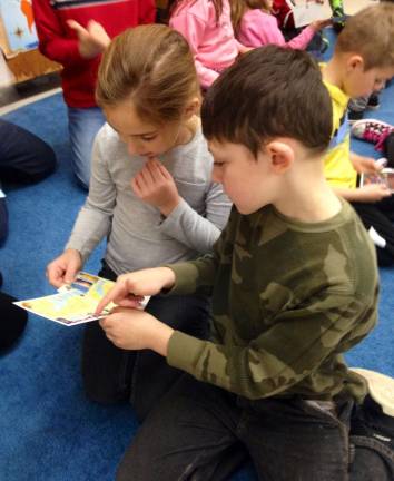 Pictured, from left, Jamie DeRoide and Chase Grieco comparing their postcards to determine if they have matching states.