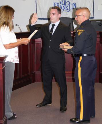 Lieutenant Cugliari is sworn in by Borough Clerk Robin Hough as Police Chief Eugene McInerney holds the bible.
