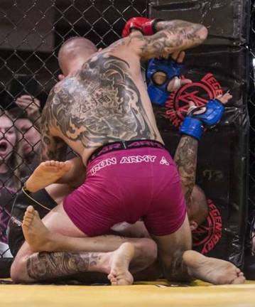 Local gym wins three championship fights Sean Santella delivers strikes against the cage in front of a partisan crowd full of Miller Brothers MMA & Fitness supporters.
