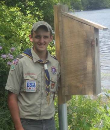 Stephen Sullivan stands next to one of the wood duck boxes he constructed.