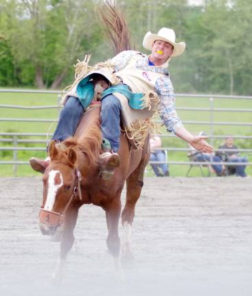 Green Valley Farm hosts rodeo An angry horse carries it's rider towards the camera during the bareback riding event.