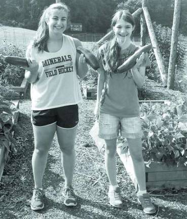 Volunteers provide produce for food pantries Pass It Along volunteers Adrianna Purcell and Emily Wetzel holding zucchini they just harvested at the Hardyston Charity Garden.