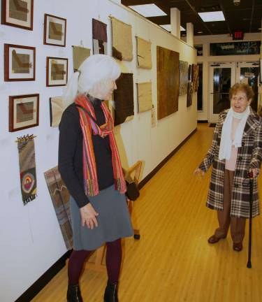 Skylands Gallery show benefits Father John's Animal House Tapestry weaver Carol Chave, left, from Highland Lakes, greets Julia Quinlan. The Karen Ann Quinlan Hospice was last monthþÄôs benefiting charity